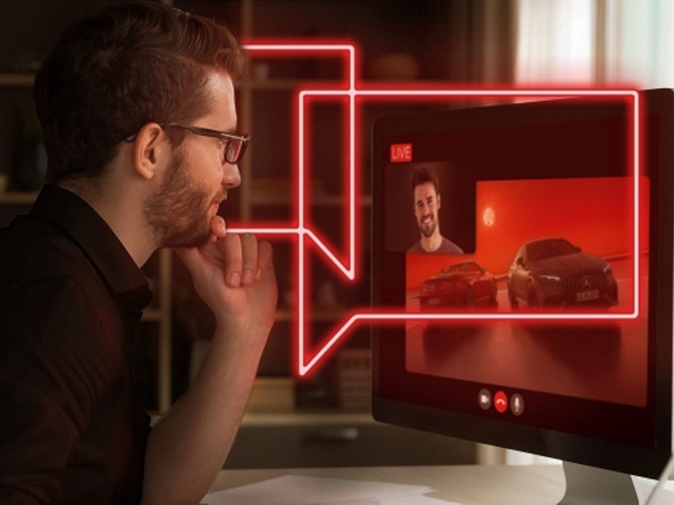 A man sits in front of a computer and watches AMG Live Talk.